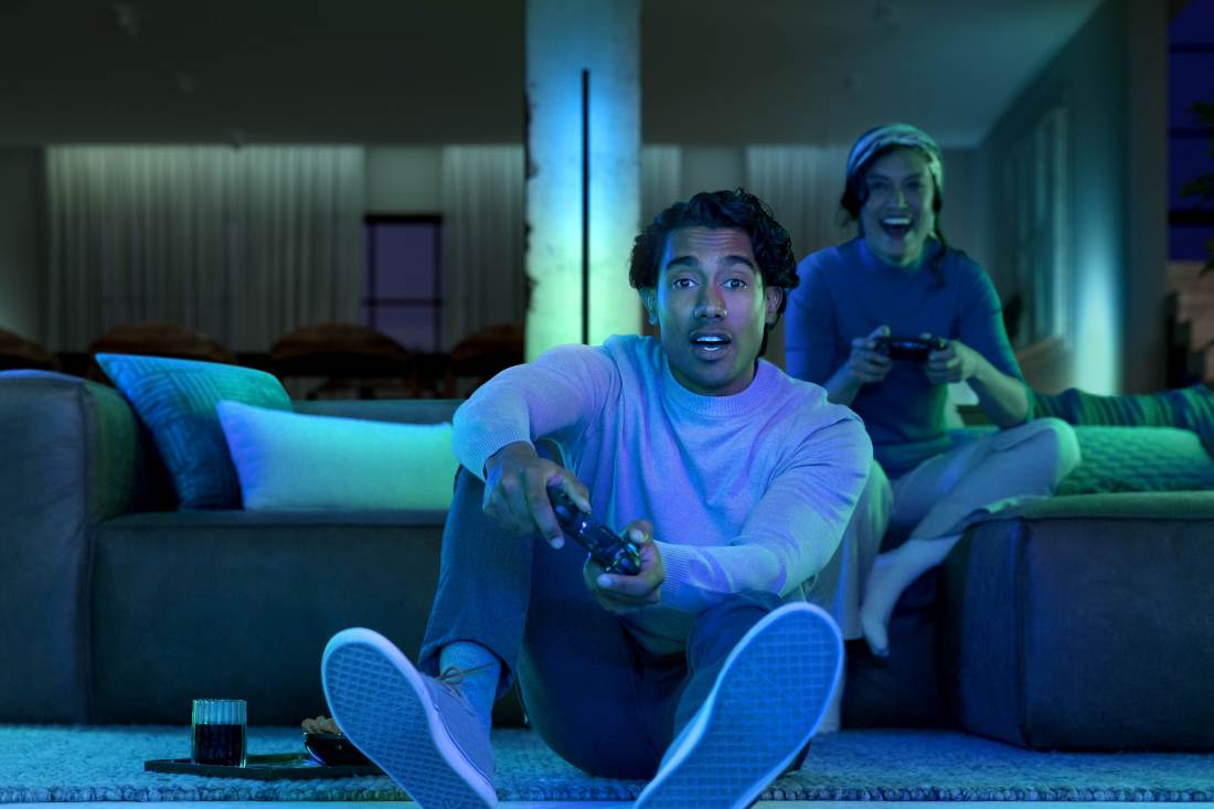 Par spelar tv-spel som synkas med Philips Hue belysning.